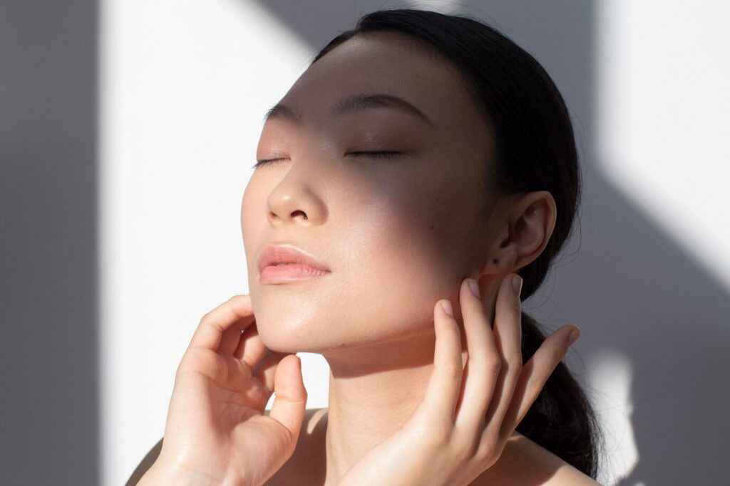 beautiful asian woman posing holding rose with perfect skin